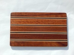 A wooden cutting board handcrafted from a variety of woods by the nuns.